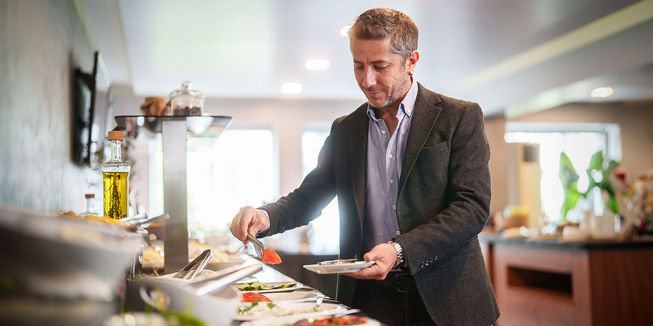 Hombre de negocios en una estación de comida de autoservicio en un hotel