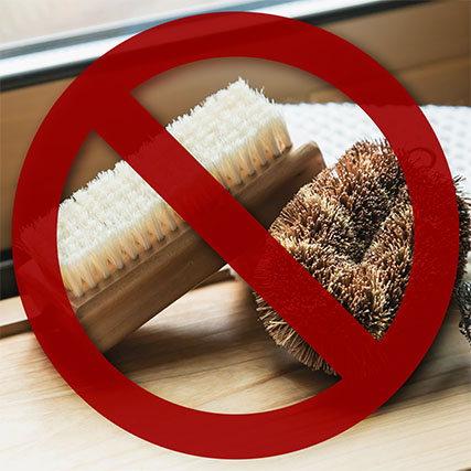 close-up of scrubbing sponges and bristle brushes with a red cross-out