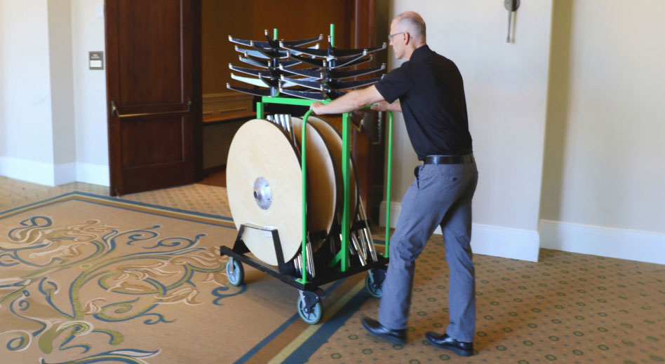 Man Pushing Cart Full of Tables