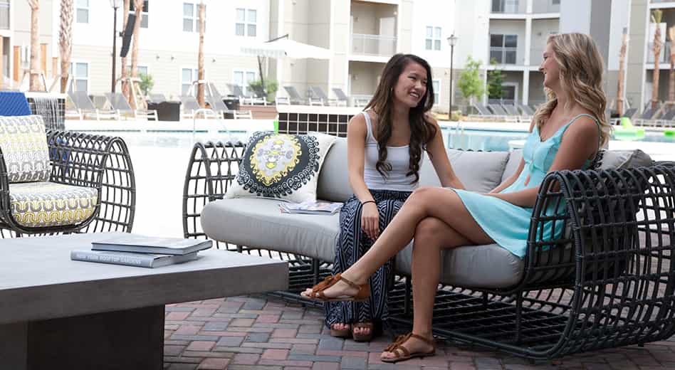 People seated on a Linden outdoor sofa by MityLite