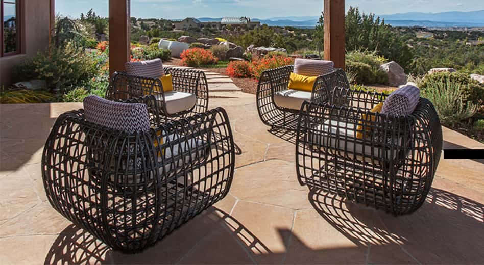 Mobilier d'extérieur en Tilleul noir sous une pergola dans un décor lumineux aux couleurs terre cuite