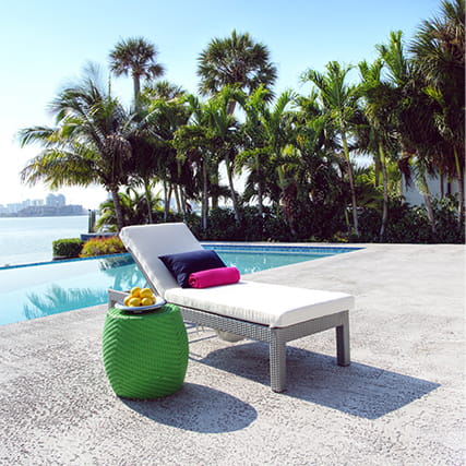 Chaise longue blanca de VITA Outdoor situada junto a la piscina