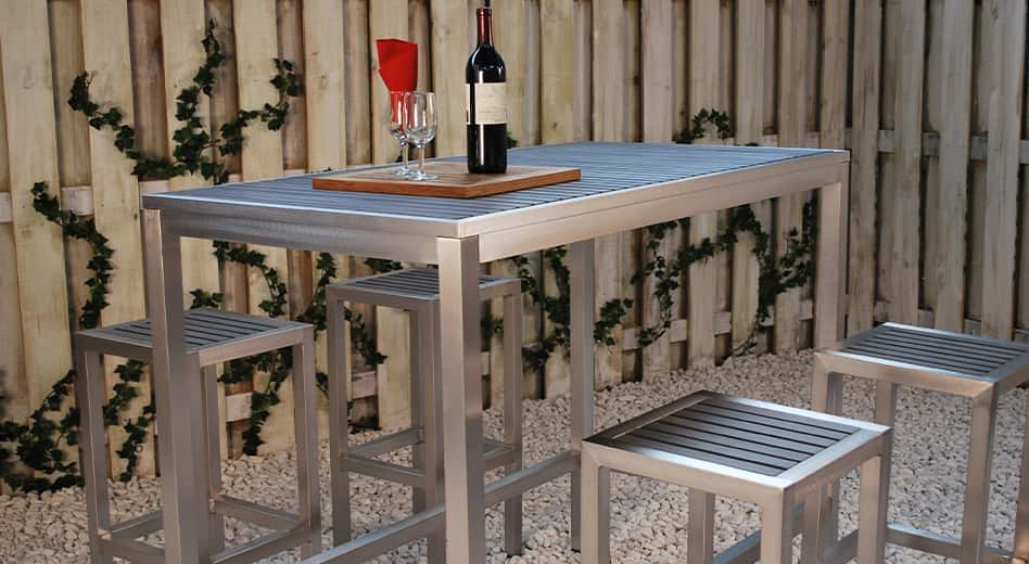 metal outdoor barstools and table in a gravel-covered outdoor space