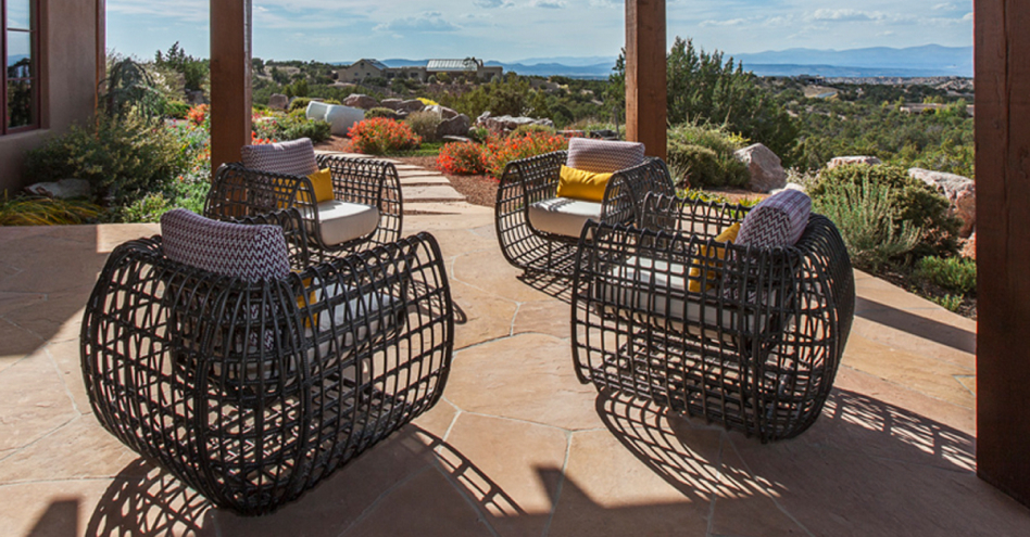 Faux-wicker outdoor furniture on covered patio overlooking desert