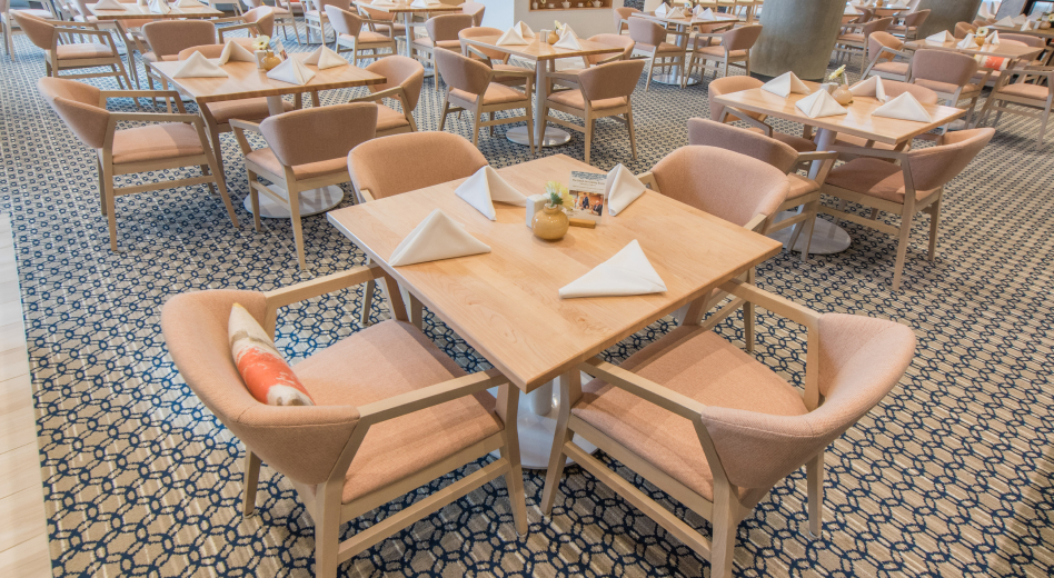 A room full of attractively upholstered armchairs at dining tables