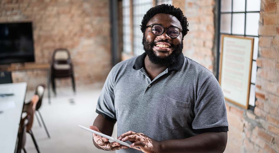 Employee in a venue meeting space holding a tablet