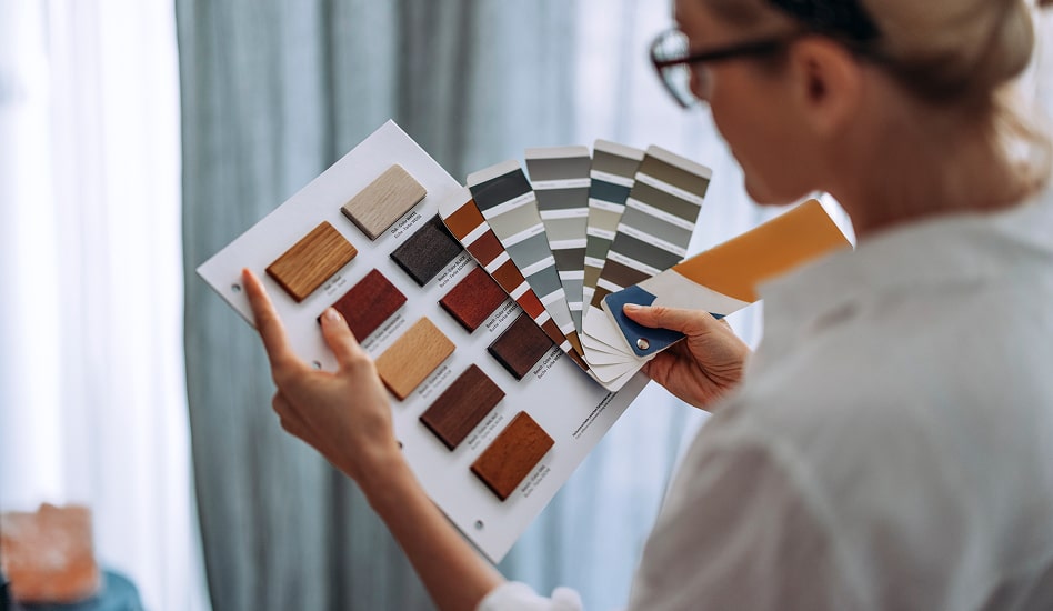 A designer compares wood finishes to paint swatches