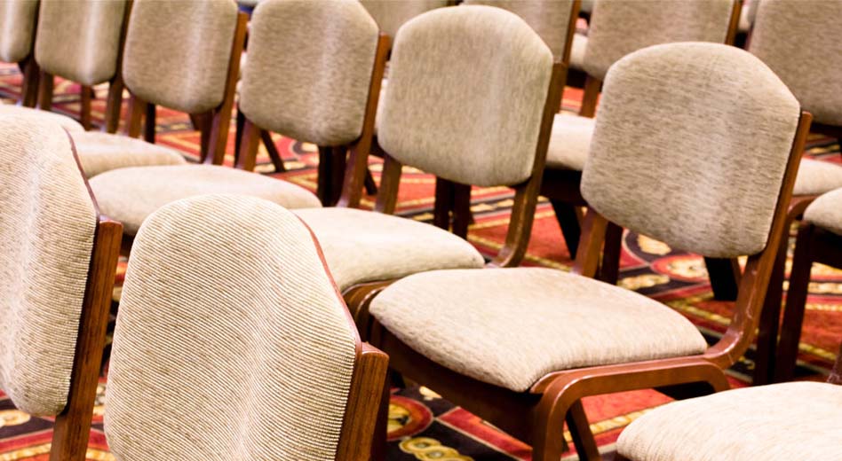 Upholstered wooden chairs arranged in rows